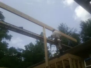 Carpenter setting a ridge beam over a new addition frame — Ice Dam Removal by Roofing Brothers in Lyman